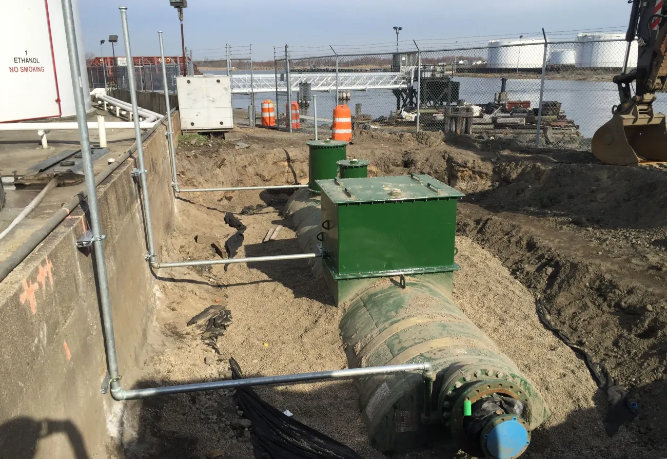 Excavation and pipe work beside a concrete wall on a commercial site
